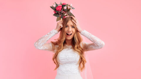 a shocked, confused, unsure bride in a wedding dress, a frightened girl on a pink background