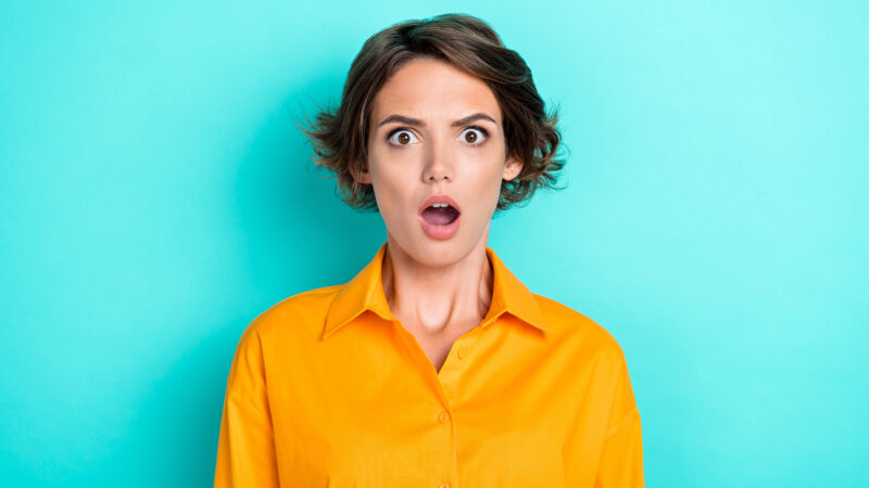 Photo of adorable cute nice girl with bob hairdo dressed yellow shirt scared horrified staring isolated on turquoise color background