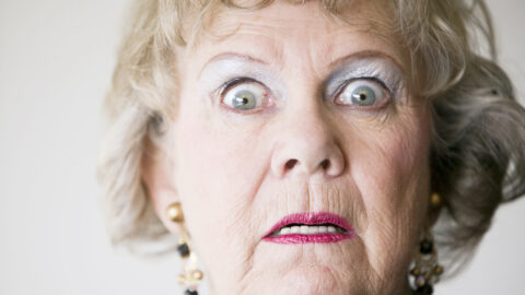 Close-up of a senior woman with a horrified look on her face.