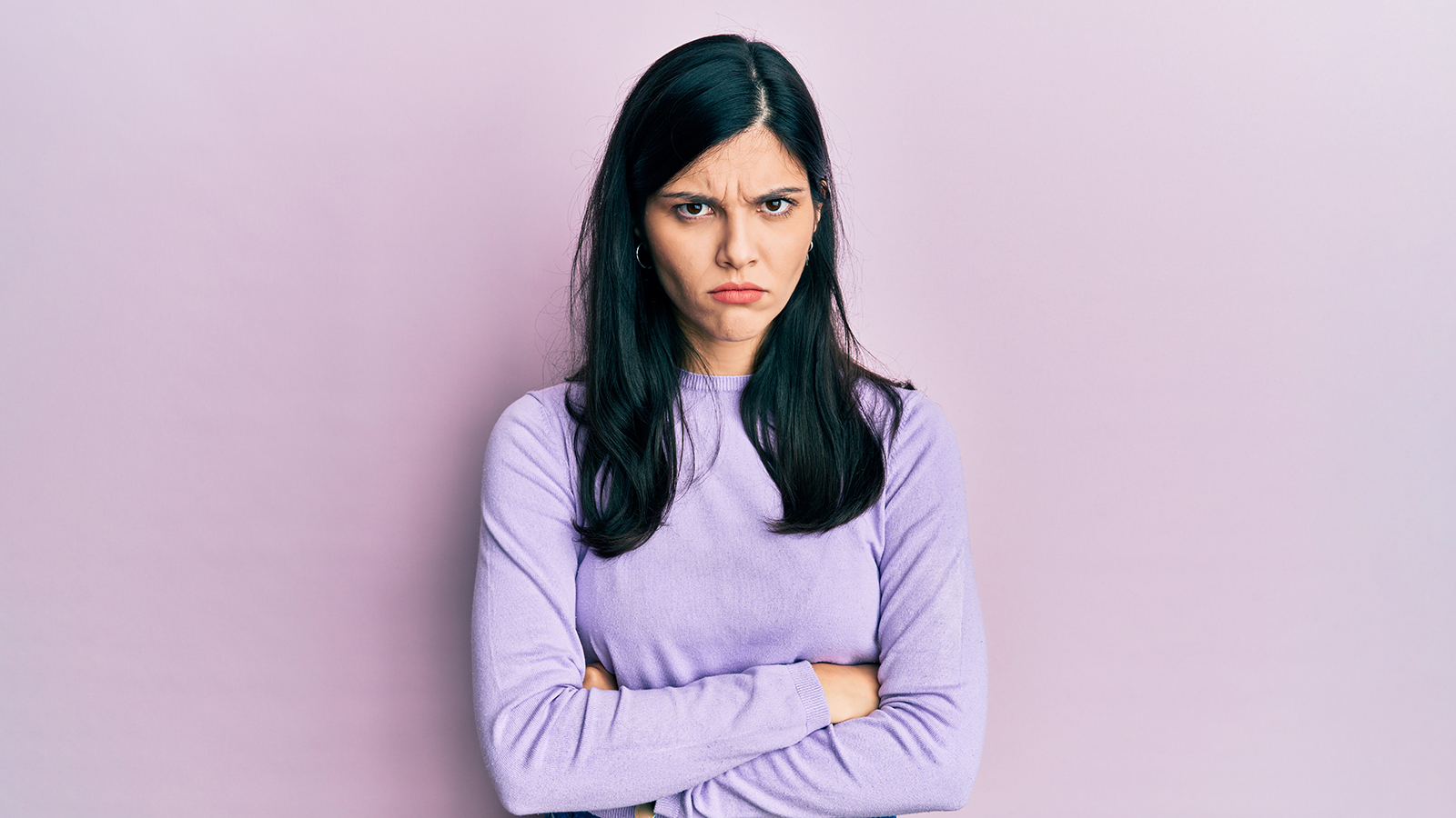 Young hispanic woman wearing casual clothes skeptic and nervous, disapproving expression on face with crossed arms. negative person.