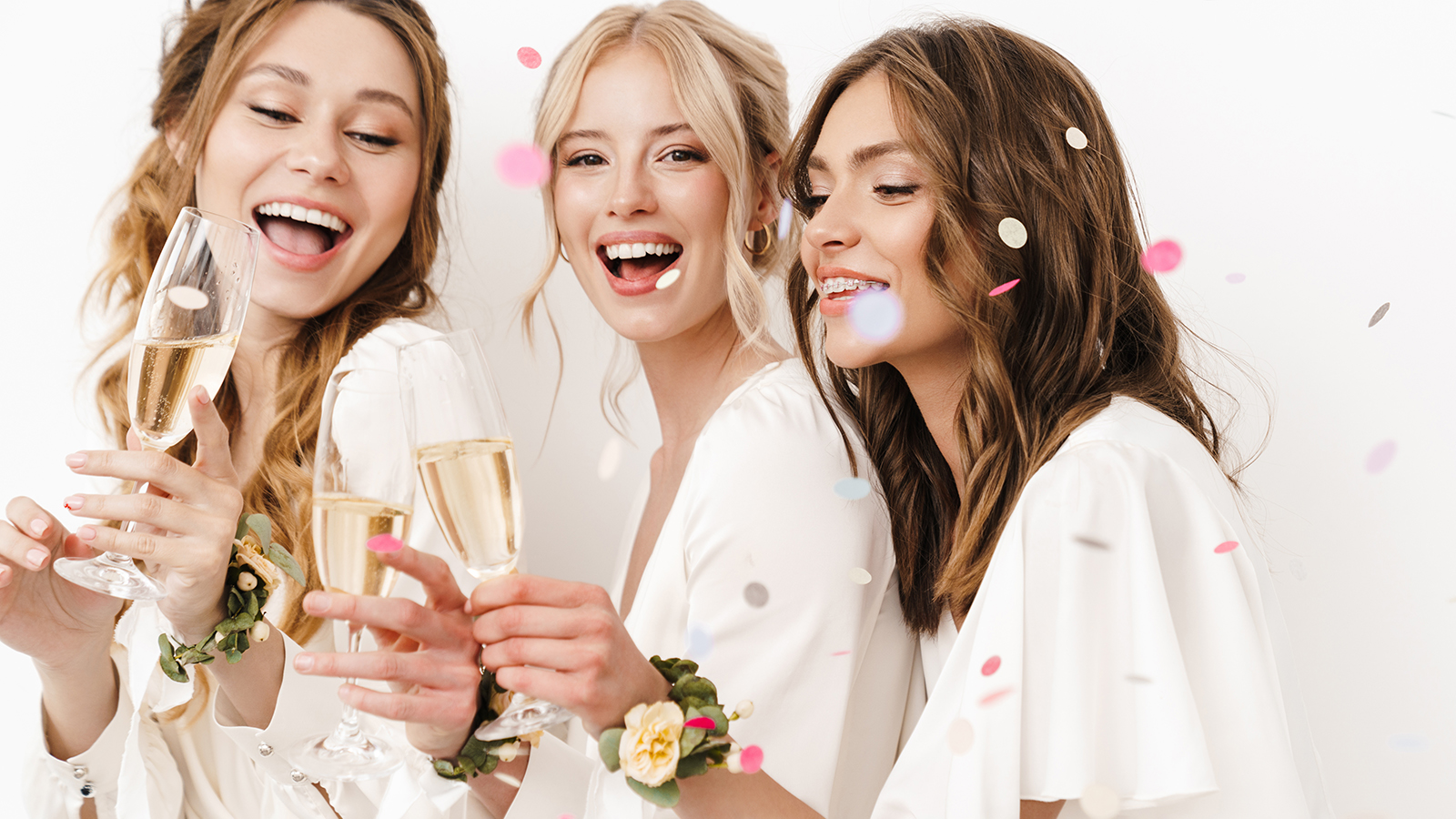 Photo of excited beautiful bridesmaids laughing and drinking champagne isolated over white wall
