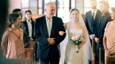 Love, wedding and church bride with father walking in aisle for ceremony with friends, family and parents. Happy, daughter and dad at Christian marriage, commitment and celebration with smile.