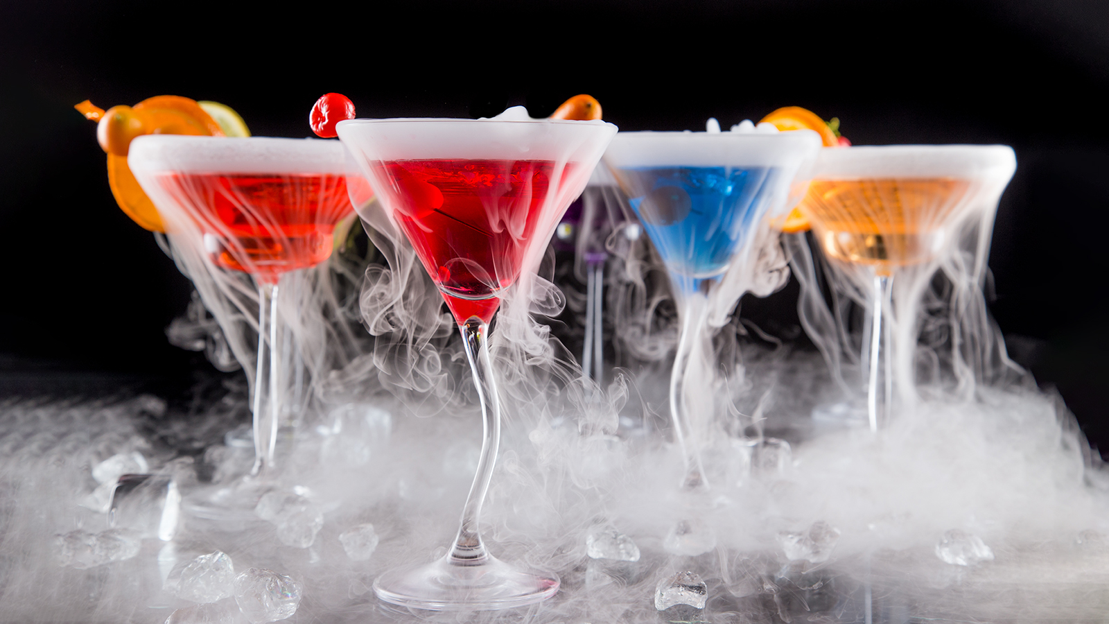 Cocktails with ice vapor on bar desk, close-up.