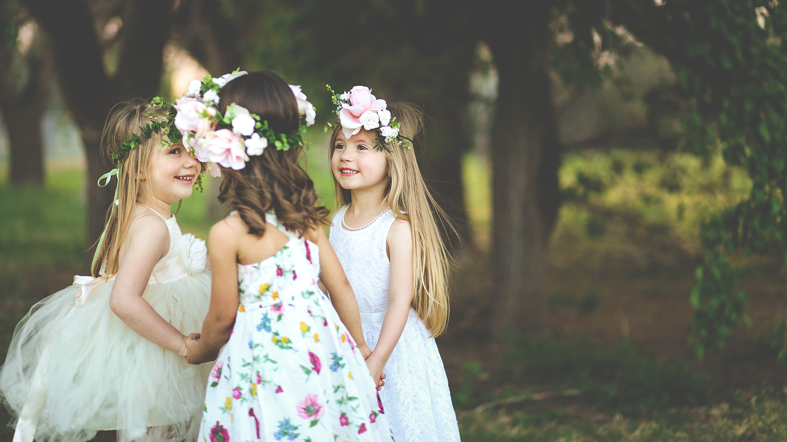 Three adorable spring girls play together in a garden