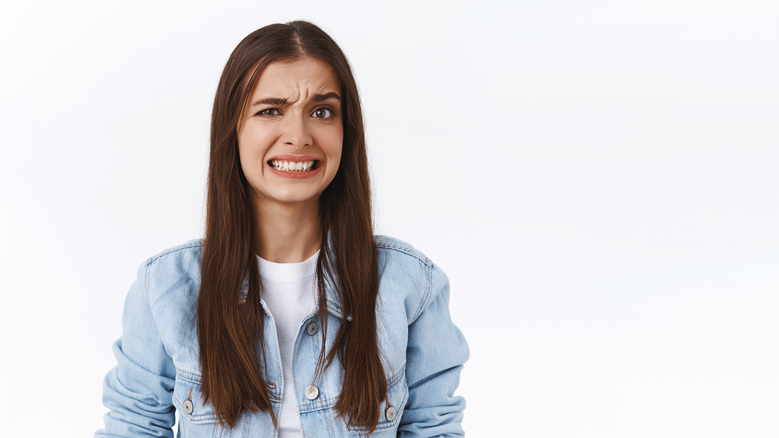 Girl cringe as seeing something embarrassing and bothering. Woman make uncomfortable smile and squinting feeling worried and displeased, see bothering bad situation, standing white background.