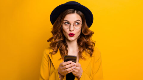 Close up photo beautiful she her lady watch sly tricky side empty space arms hands telephone reader cool news modern look wear specs formal-wear costume suit isolated yellow vibrant background