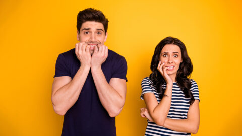 Portrait of his he her she nice attractive lovely funny horrified people married spouses showing fear expression scary movie film cinema isolated over bright vivid shine yellow background