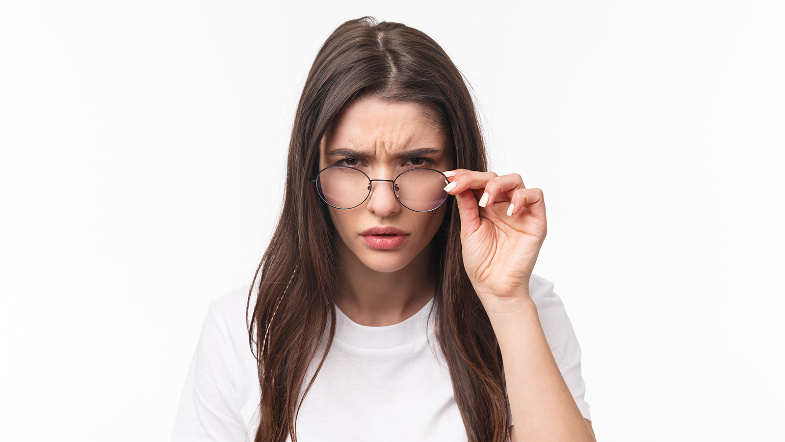 Close-up portrait of suspicious young serious-looking woman, look from under glasses, squinting at person with judgemental disbelief stare, standing white background, have doubts