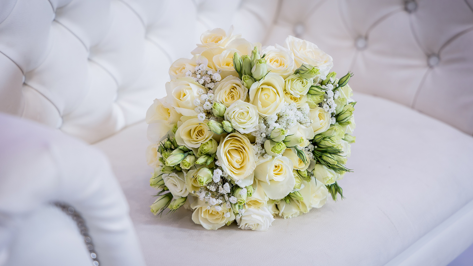 Orthodox Hasidic Jewish wedding bride chair with flowers for traditional event. Cream and white background with orchids, roses, petals and leaves.