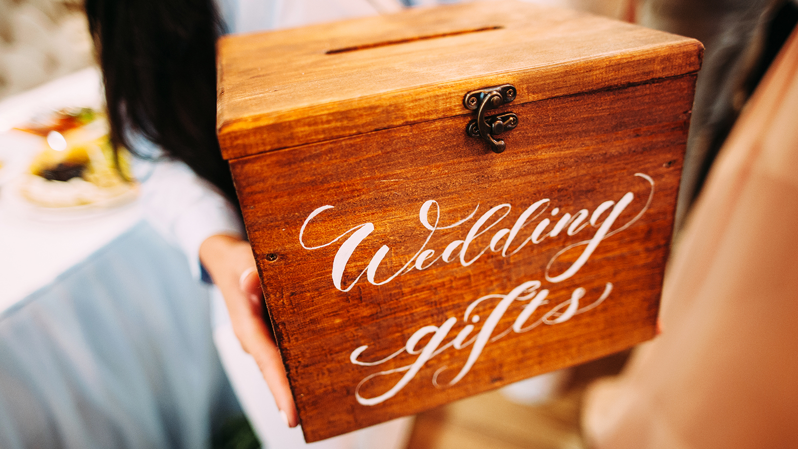 Wedding gifts. Bridesmaid holds wooden box with a sign.