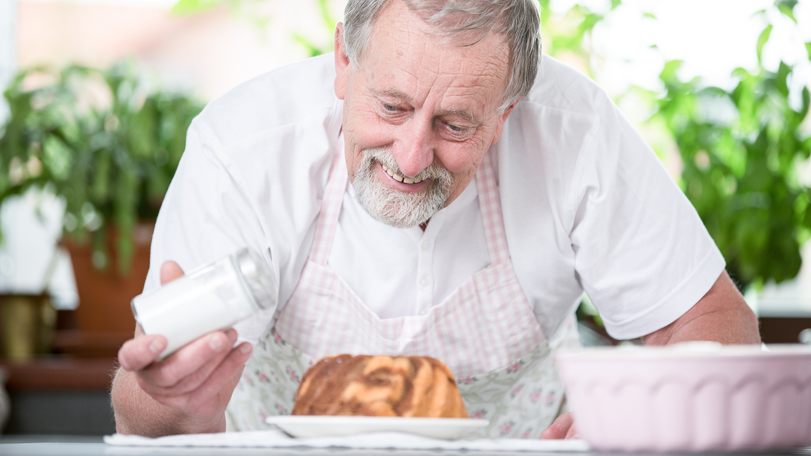 Elderly man with a cake in the kitchen