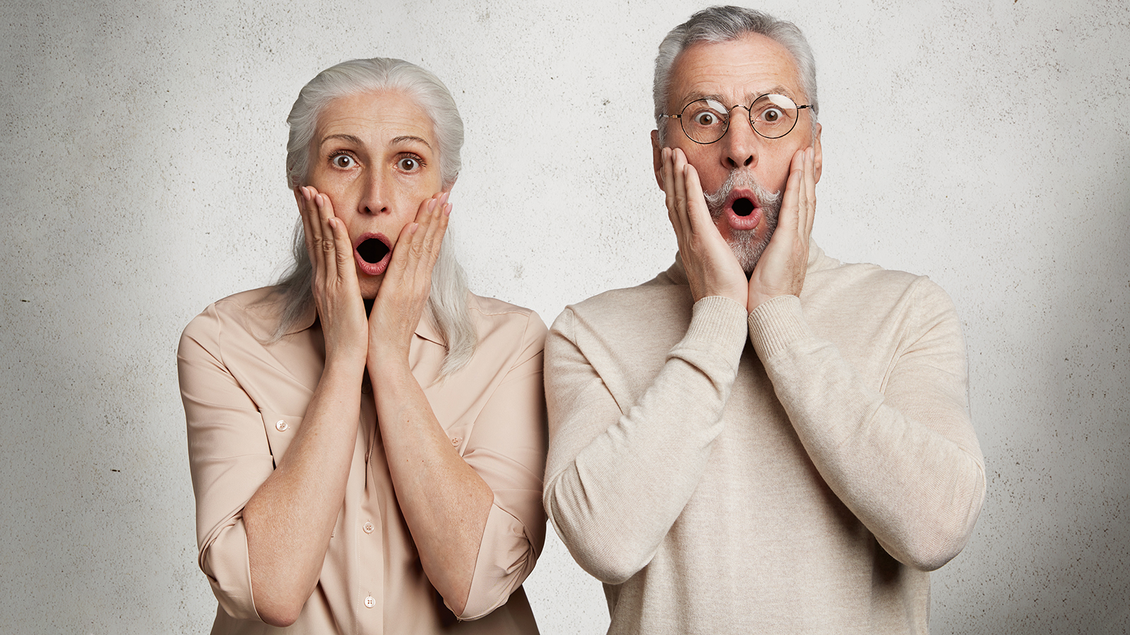 Elderly female and male stare at camera with terrified expressions, realize that they can`t pay bills, live only on pension, have financial crisis, isolated on white background. OLd couple in trouble