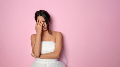 Stressed young bride on color background