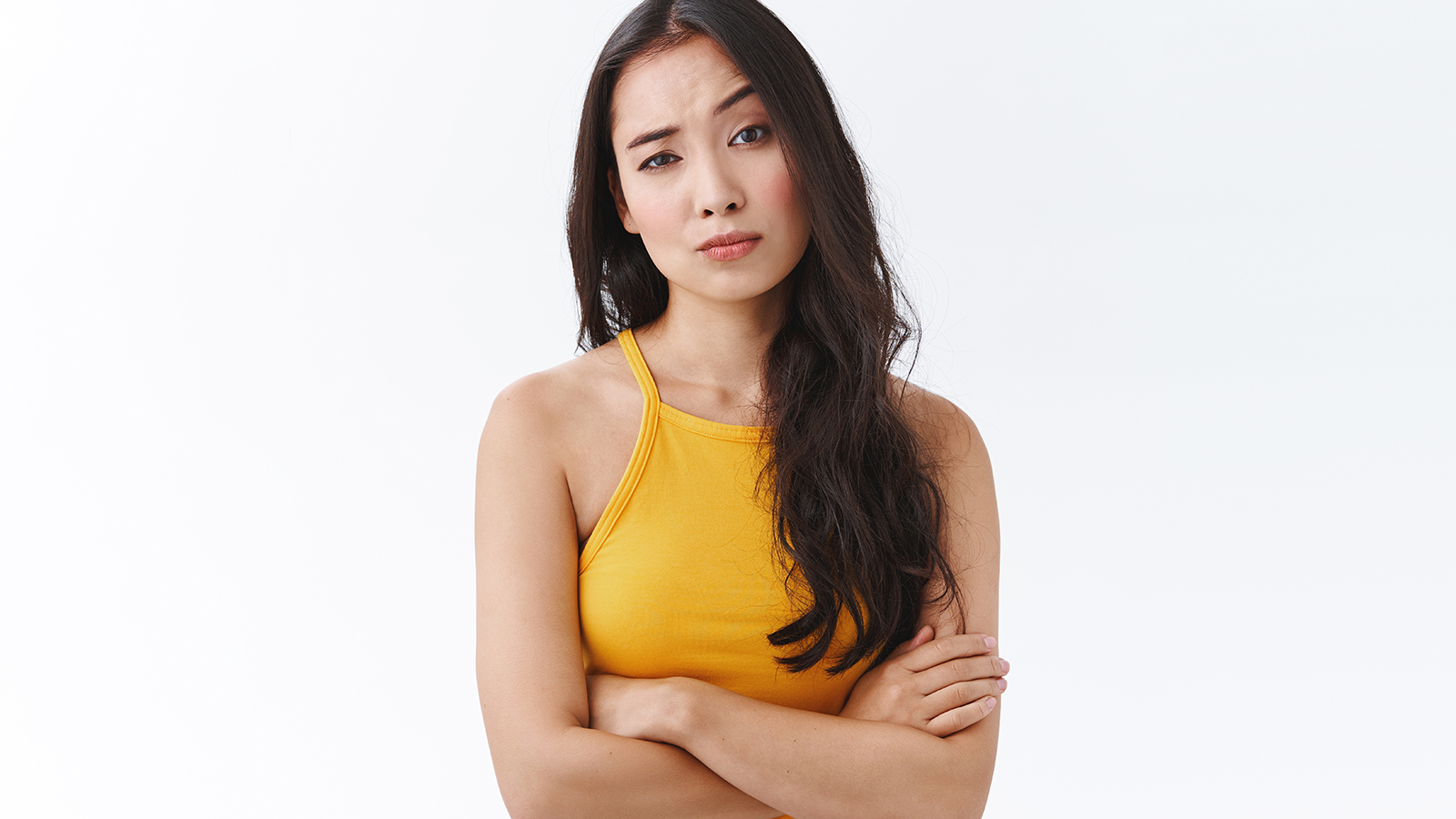 Skeptical, unimpressed pretty east-asian female in yellow top, cross hands on chest defensive and unamused pose, raise one eyebrow and stare judgemental being uninterseted and doubtful