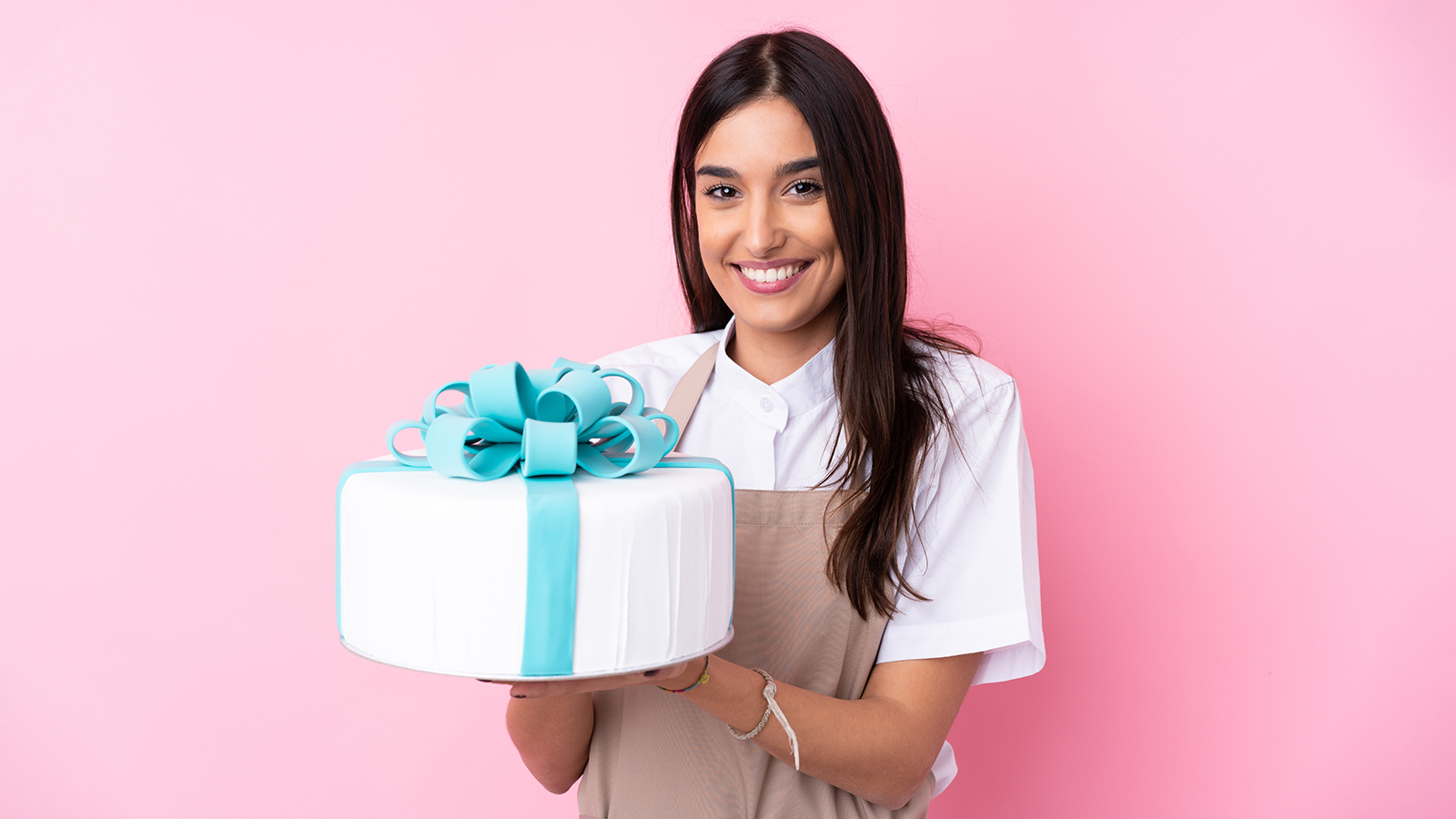 Young woman with a big cake over isolated background