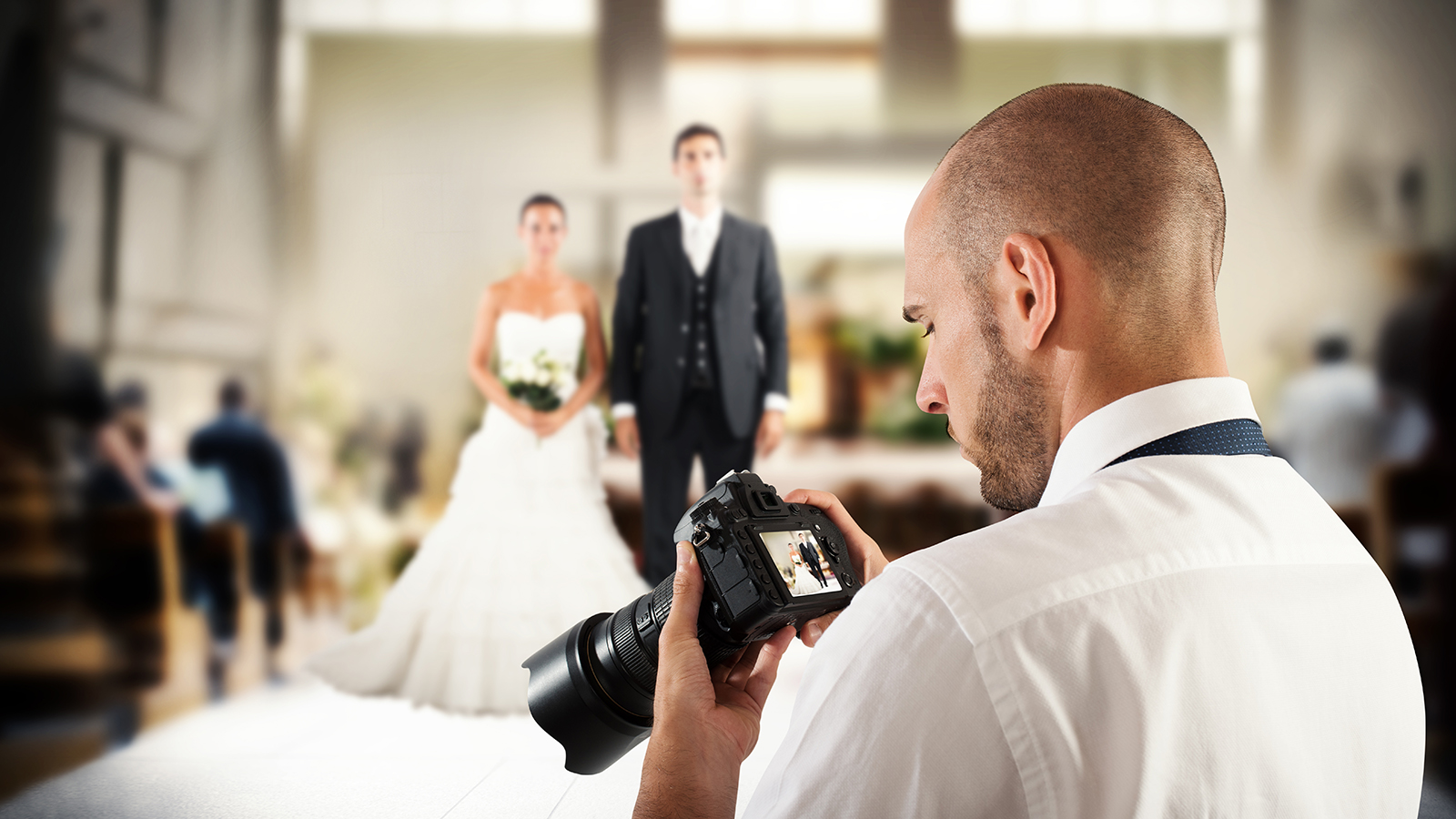 Photographer looks at the screen of camera to a wedding