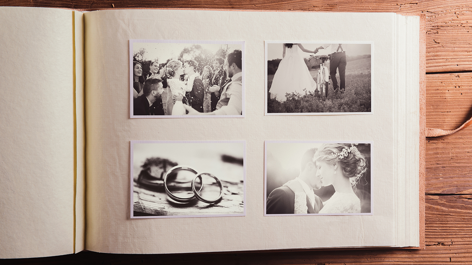 Wedding photos in album. Studio shot on wooden background.
