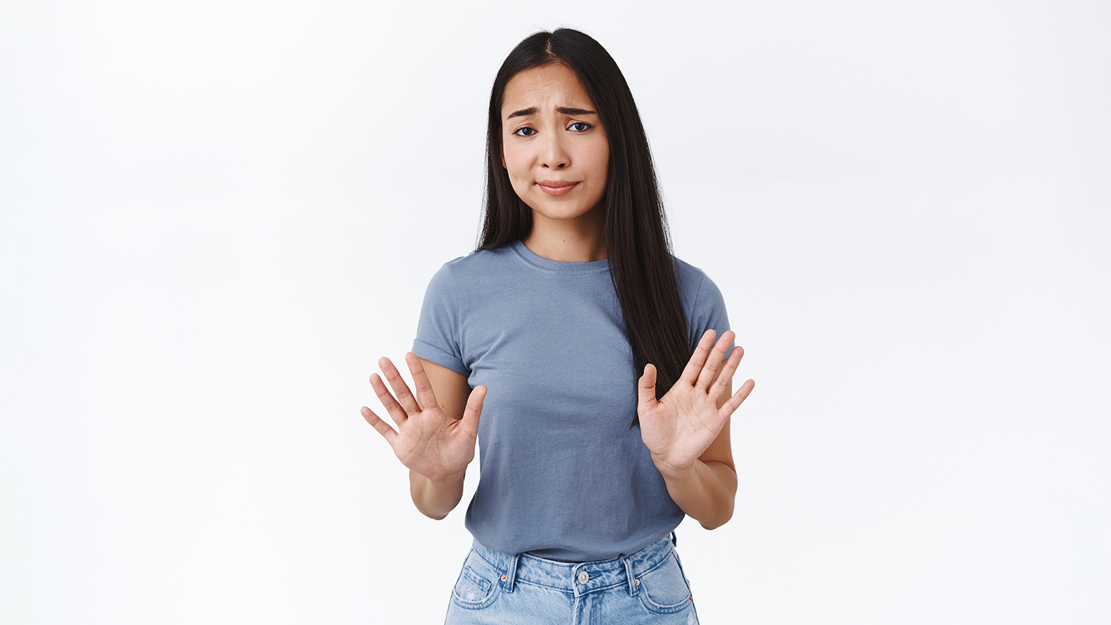 Skeptical, arrogant and unamused asian woman, raising arms in stop, refusal motion, smirk and frowning judgemental dislike offer, uninterested in product, standing white background