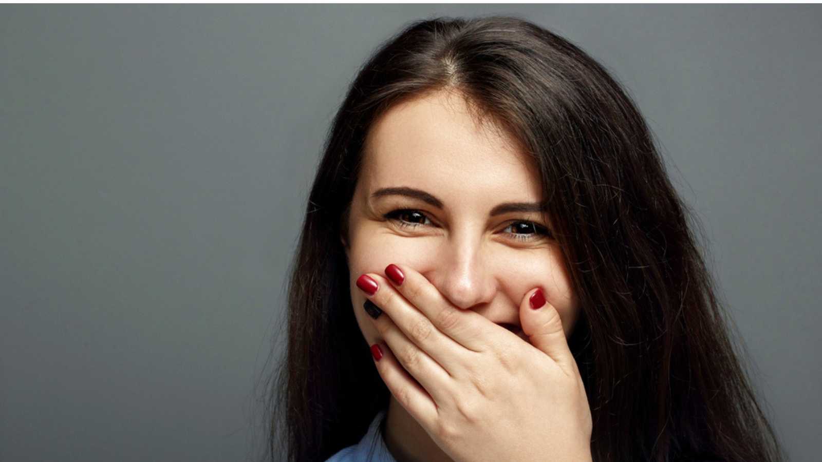 Woman laughing covering mouth
