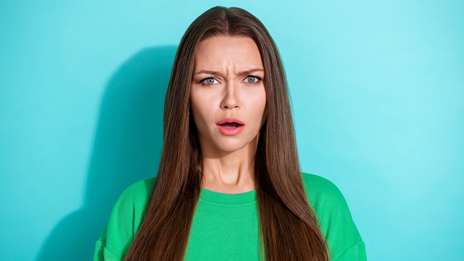 Closeup photo of young gorgeous unhappy woman shocked have conflict looking you isolated on aquamarine color background