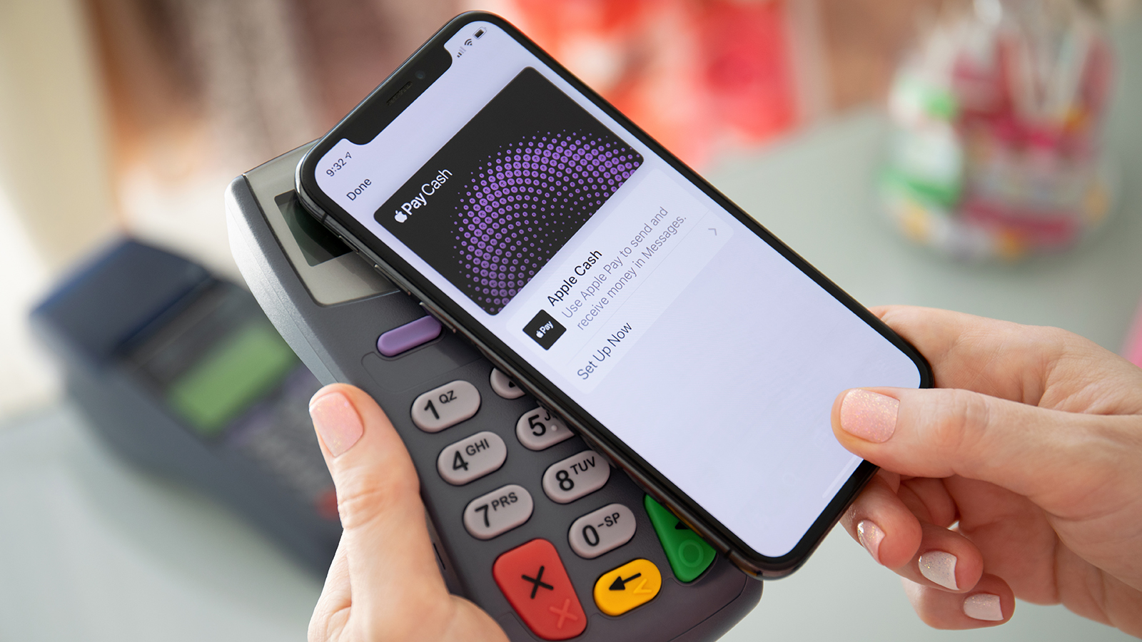 Anapa, Russia - August 10, 2019: Woman hand holding iPhone X with Apple Pay Cash on the screen and pay pass online terminal. iPhone was created and developed by the Apple inc.