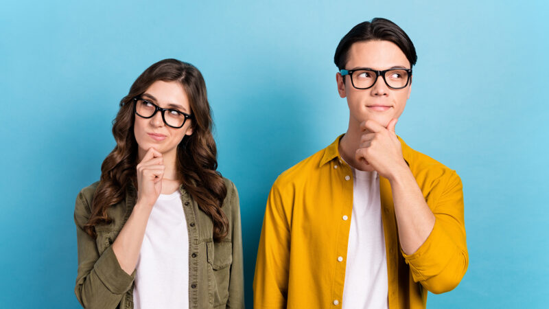 Photo of funny suspicious married couple wear shirts spectacles looking empty space isolated blue color background