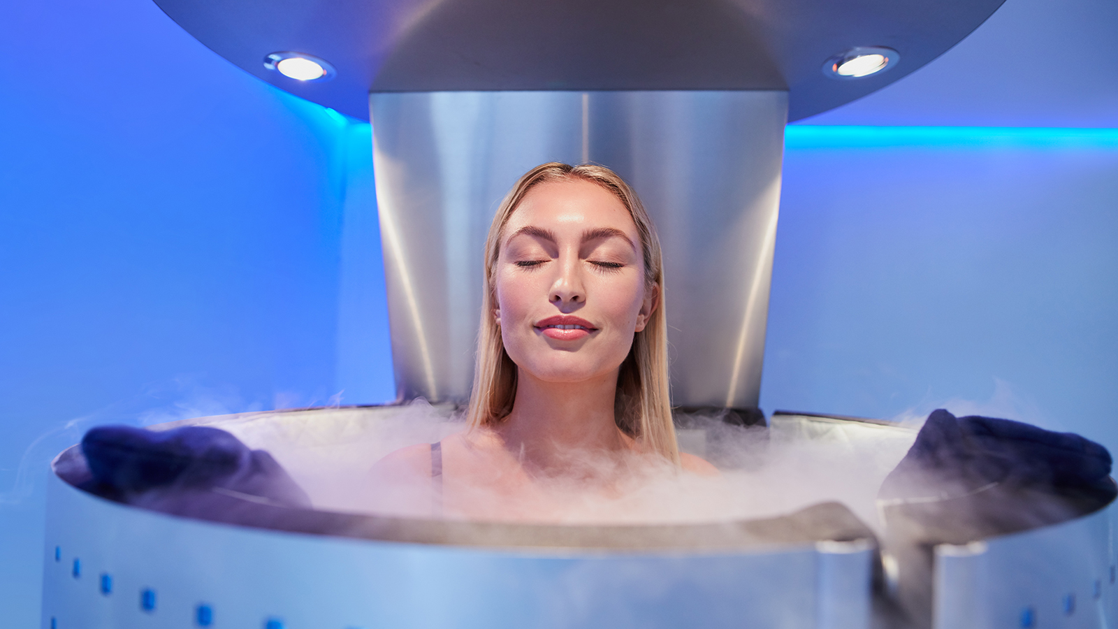 Portrait of happy young woman in a whole body cryotherapy cabin with her eyes closed. Cryosauna chamber for overall increase in muscular performance.