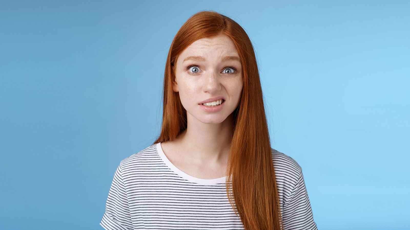 Confused stunned young doubtful redhead girl look full disbelief smirking unsure frowning cringing hesitant standing disappointed uncertain, feel awkward hearing embarrassing story. Copy space