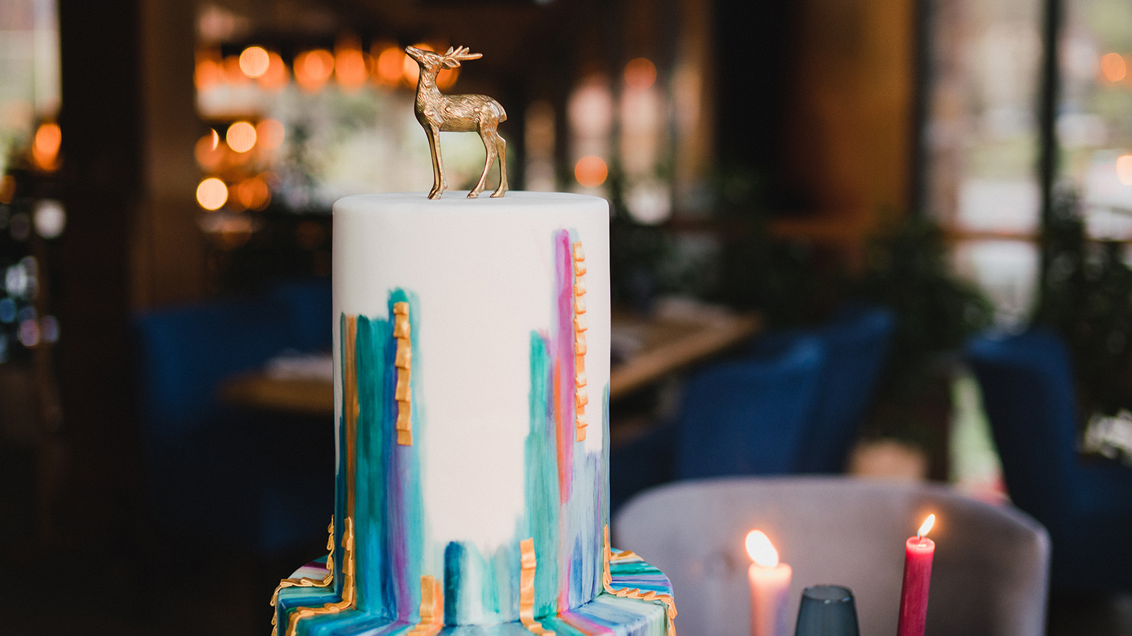 Stylish modern wedding cake. Beautiful dessert decorated with geometric print and golden deer stattuette.