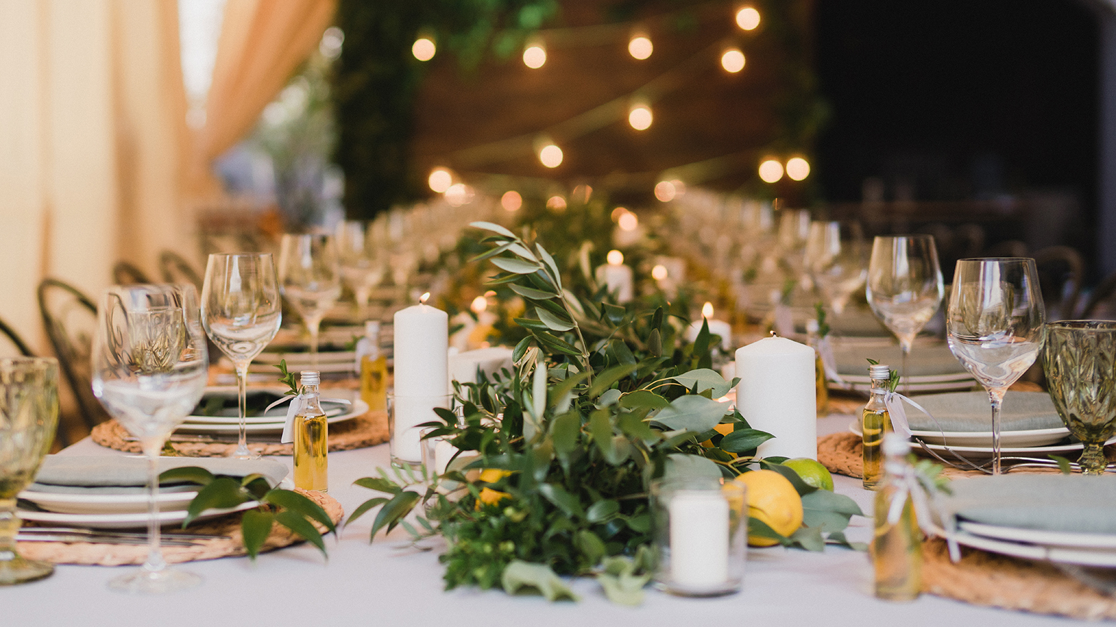 Coziness and style. Modern event design. Table setting at wedding reception. Floral compositions with beautiful flowers and greenery, candles, laying and plates on decorated table.