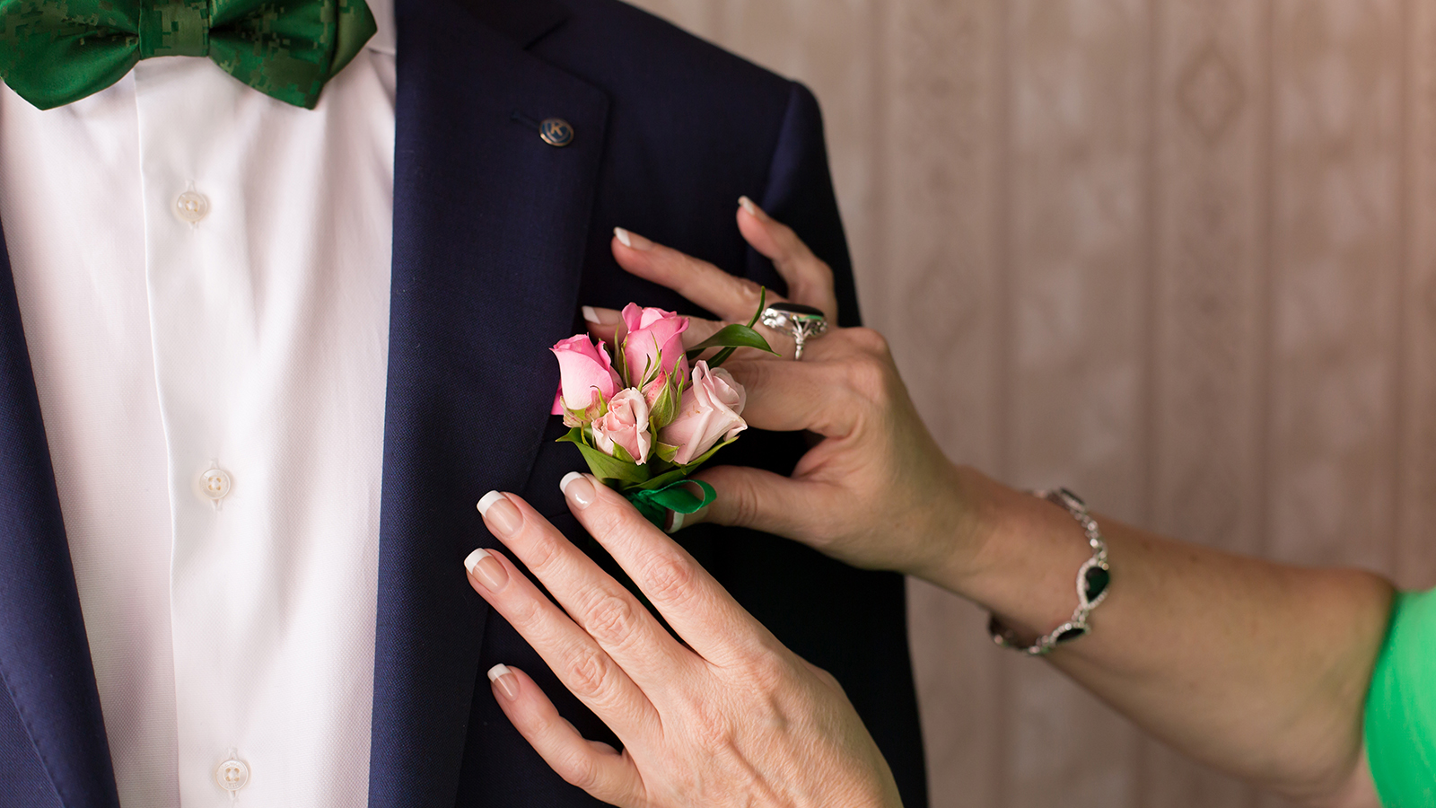hands of mother correct a buttonhole for the groom