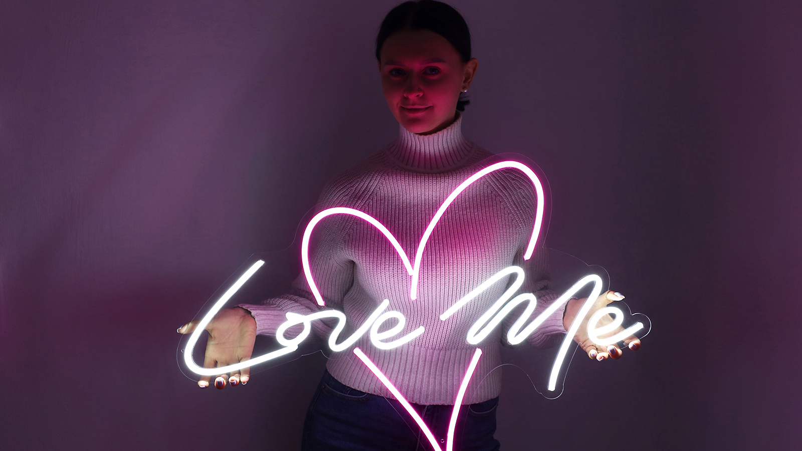 Beautiful girl with neon signs. White and pink neon heart with the inscription love me. Trendy style. Wedding design. Neon sign. Custom neon. Home decor.