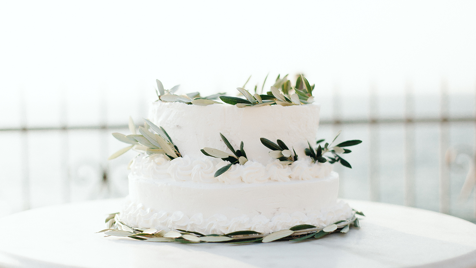 white wedding cake with olives and olive leaves