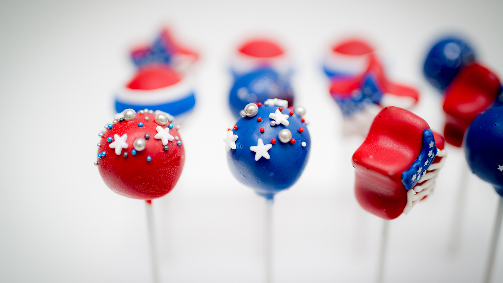 Vibrant red, white, and blue patriotic cake pops with a white background.