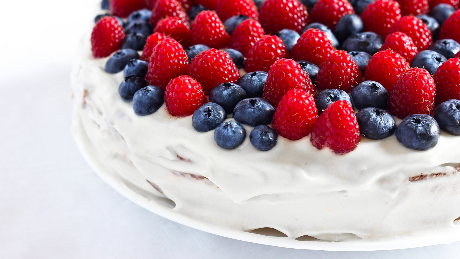 Creamy sweet cake with blueberries and raspberries