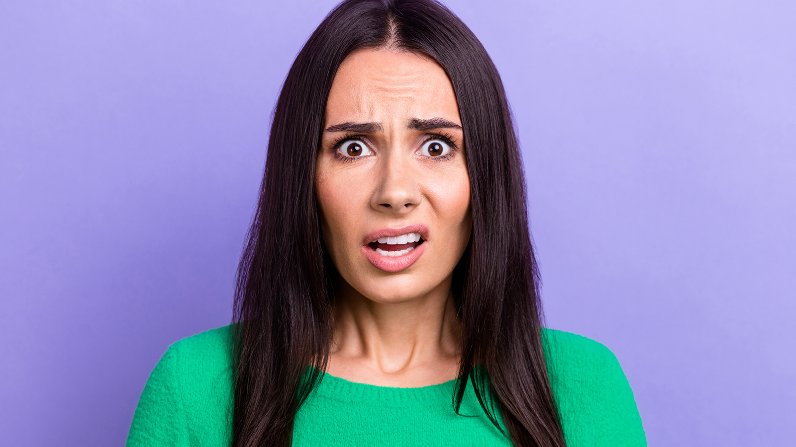 Photo of shocked impressed lady dressed green sweater listening bad news isolated violet color background.