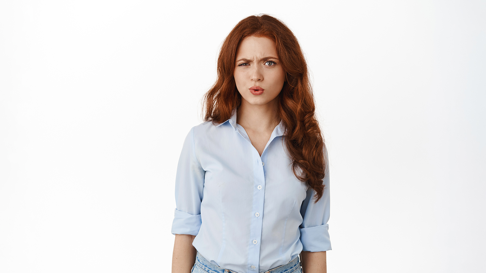 Confused redhead female office manager staring puzzled, frowning and looking with doubtful and skeptical face, cant understand something strange, standing questioned against white background