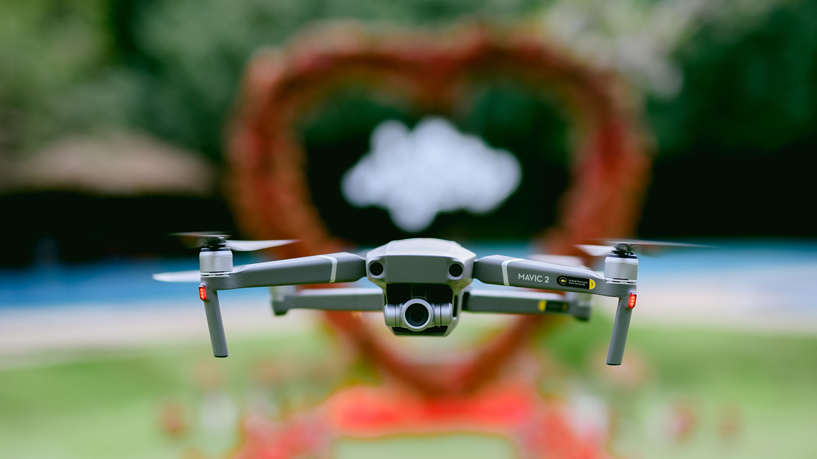 Piliyandala, Sri Lanka - November 2022 : Dji Mavic 2 Zoom drone in the air during an engagement proposal event. Outdoor marry me party decorations made from roses.