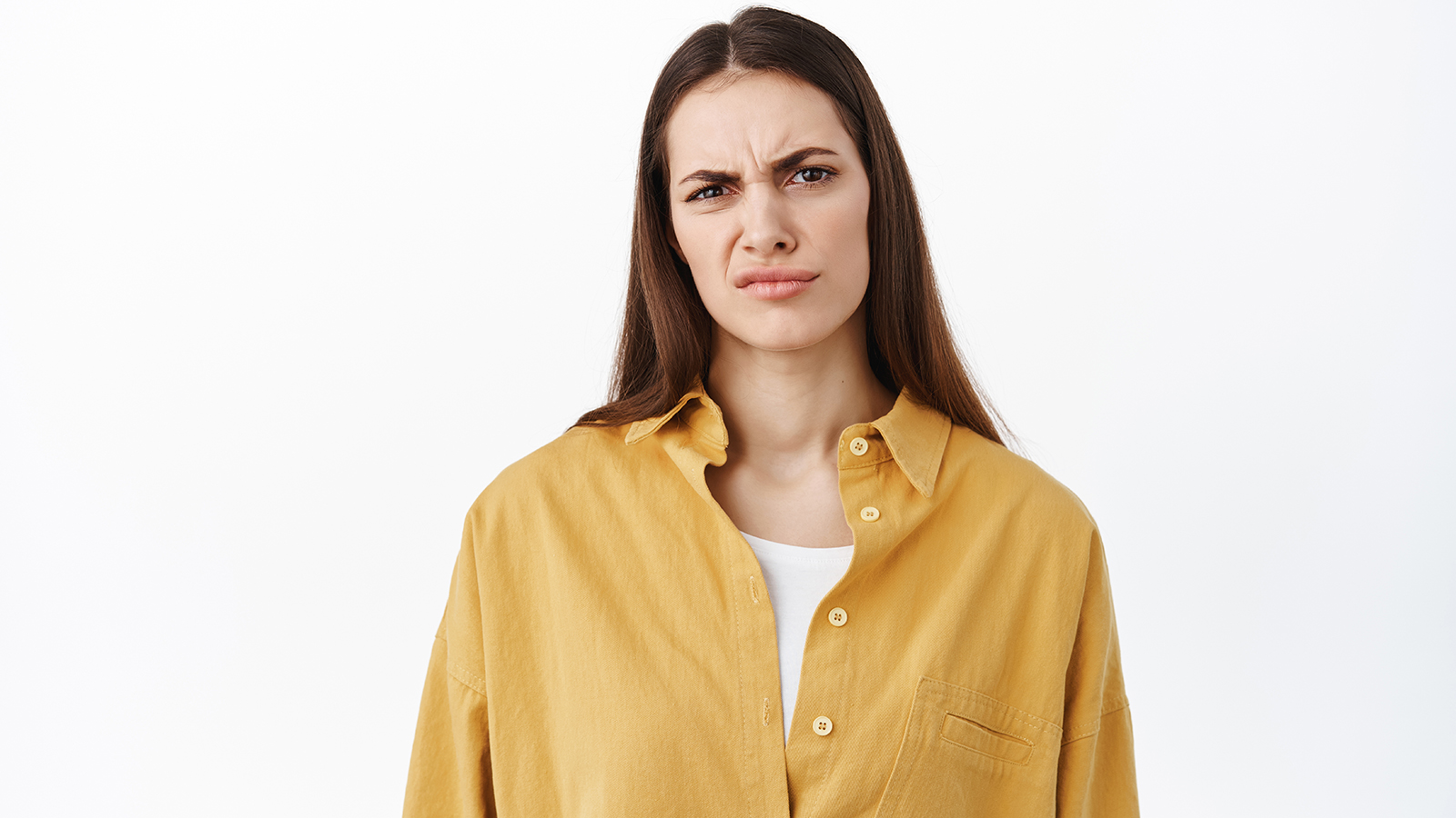 Woman grimacing and frowning as looking at something bad, cringe from awful content, stare disappointed and judgemental, judging express dislike, standing over white background