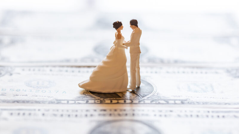 Miniature figures of groom and bride on paper money.