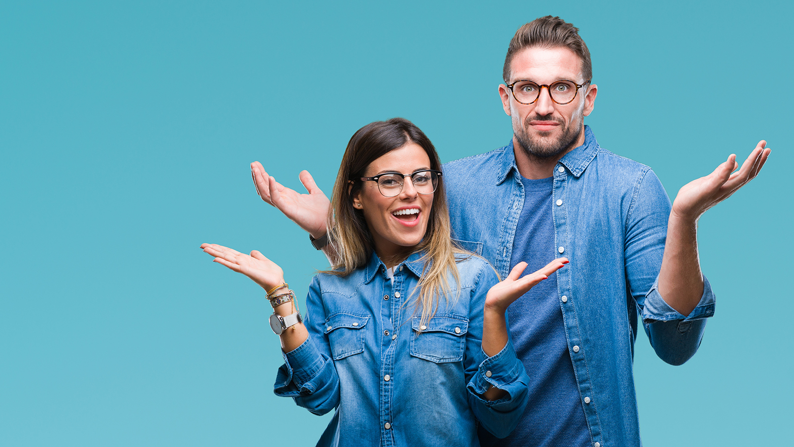 Young couple in love wearing glasses over isolated background clueless and confused expression with arms and hands raised. Doubt concept.