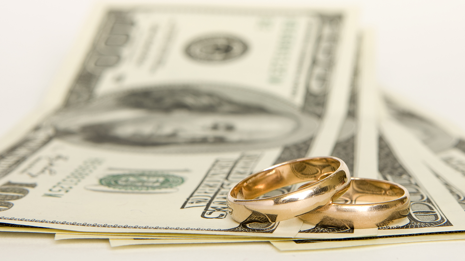 Wedding rings and money on a white background