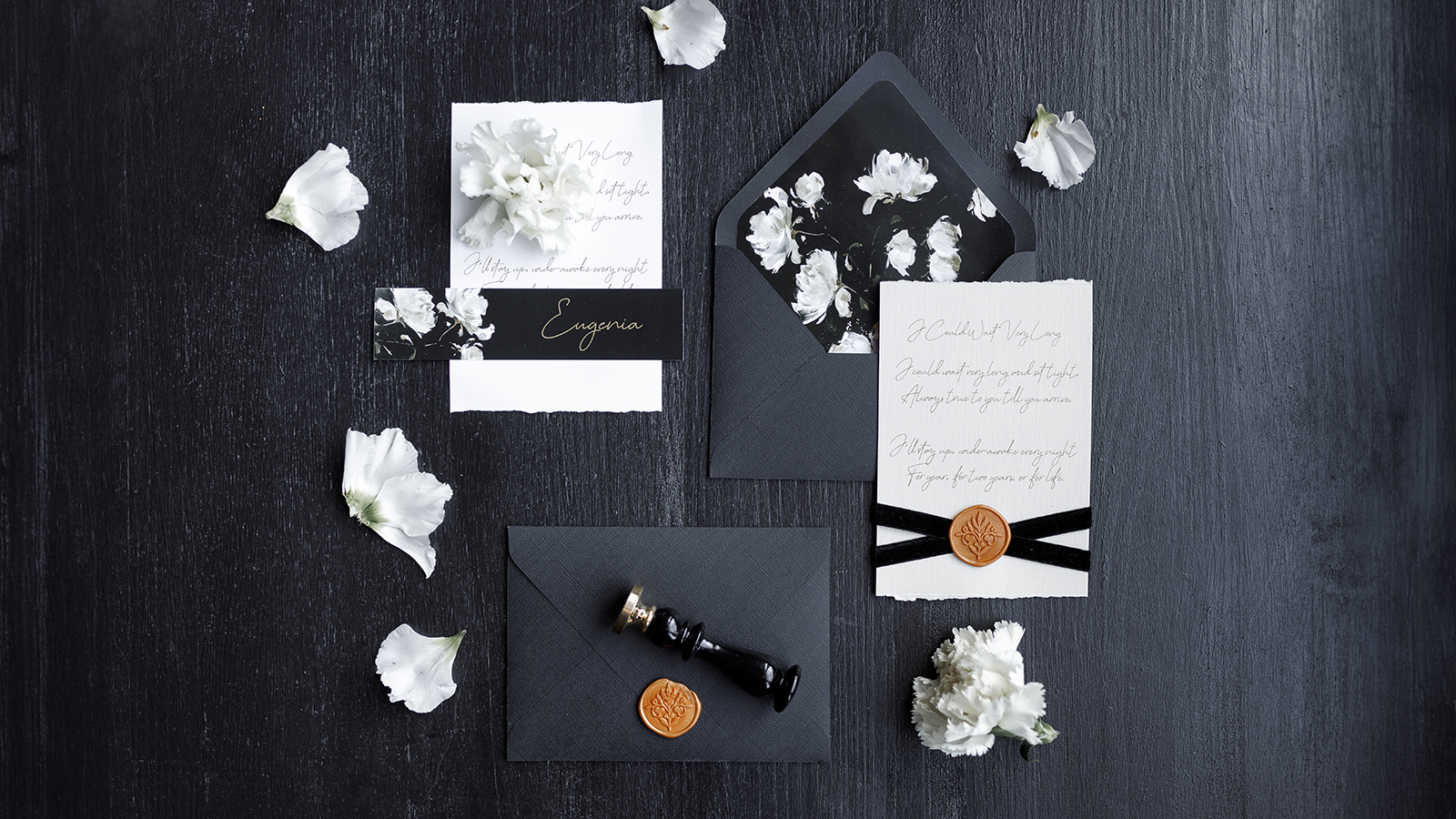 A set of dark wedding printing on a wooden background. Wedding invitation, trendy black background with flower petals.