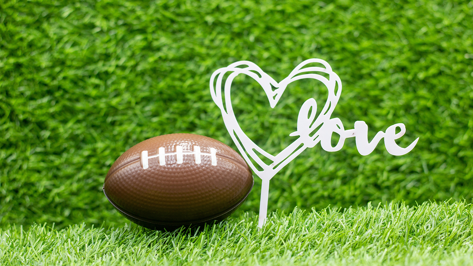 American Football with love on green grass