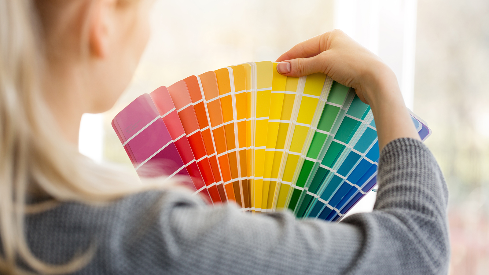 woman designer choosing interior design color from swatch palette