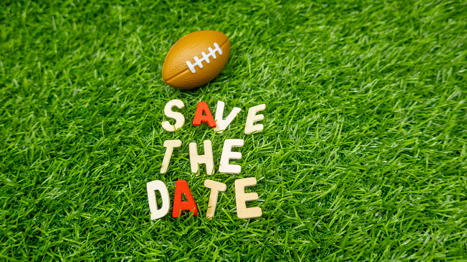 American football save the date on green grass