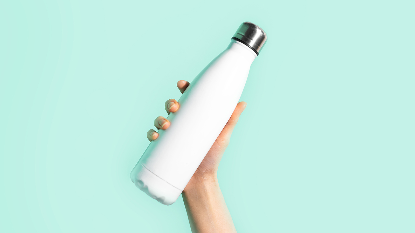Close-up of female hand, holding white reusable steel stainless eco thermo water bottle with mockup, isolated on background of cyan, aqua menthe color. Be plastic free. Zero waste.