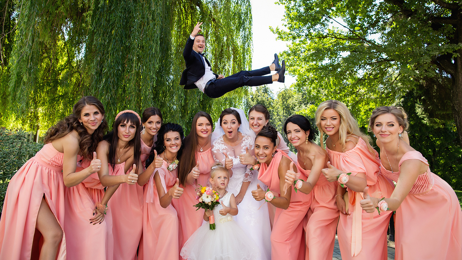 Crazy Wedding. Bride and bridesmaids having fun after wedding ceremony. Groom flying in background with help of groomsmen. Bridesmaid dresses. Bride groom and guests at wedding day. Wedding concept